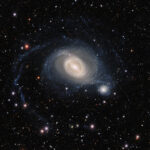 Vedeți cum o mare galaxie spirală își îmbrățișează vecinul
